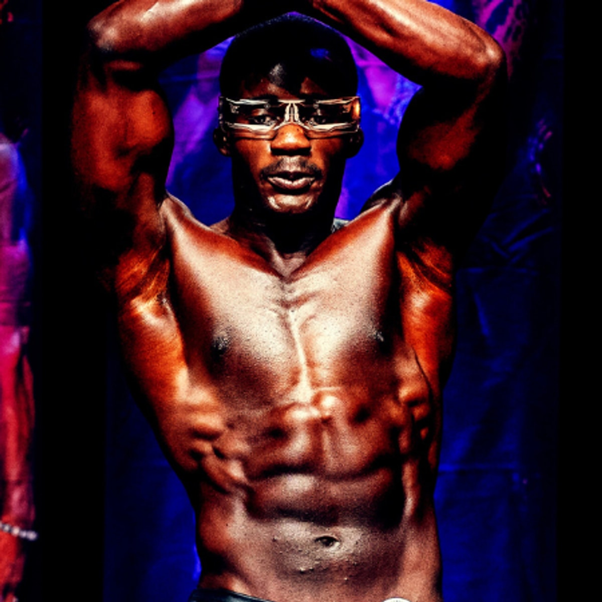 Dr. Demetrius Moore posing on a bodybuilding stage